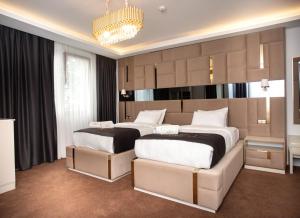 a bedroom with two beds and a chandelier at Pelit Park Hotel in Trabzon
