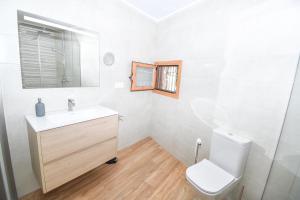 a white bathroom with a toilet and a sink at Vicino al mare in Santa Pola
