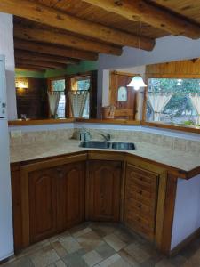 a kitchen with wooden cabinets and a sink at Maitenkarú in San Carlos de Bariloche