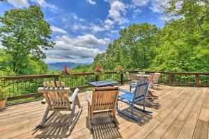 a deck with four chairs and a table and chairs at Panoramic Mtn Views Luxe Smoky Mountain Cabin! in Waynesville