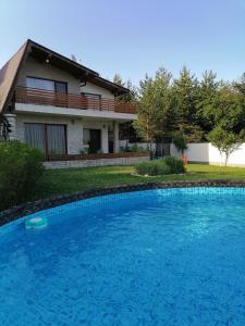 uma grande piscina azul em frente a uma casa em Къща за гости Радост Guest House Radost em Razlog