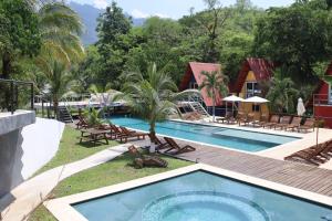 una piscina con sillas y un complejo en Greengos Hotel, en Lanquín