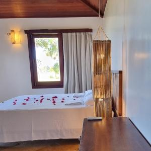 a bedroom with a large bed with a window at Casa Della in Luis Correia