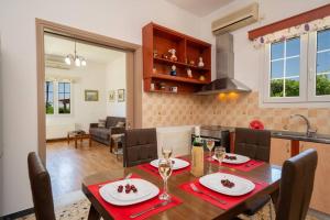a kitchen and dining room with a table and chairs at Villa Erasmia- House 1 ground floor in Sarláta