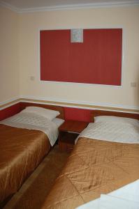 a room with two beds and a red wall at Hotel Restauracja Redos in Nysa