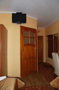 a room with a door and a television on the wall at Hotel Restauracja Redos in Nysa