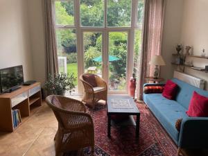 a living room with a blue couch and a large window at Spacious Holiday Home! in London