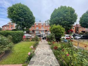 a walkway through a garden with flowers and buildings at Spacious Holiday Home! in London