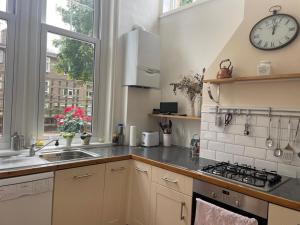 a kitchen with a sink and a clock on the wall at Spacious Holiday Home! in London +11 photos