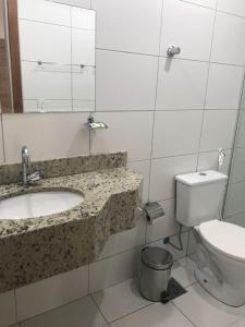 a bathroom with a sink and a toilet at Hotel Pousada Caminho da Praia in Guarapari