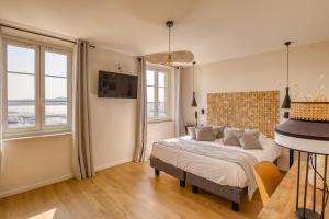 a bedroom with a bed and two windows at Hotel Restaurant de la Tour in Sanary-sur-Mer