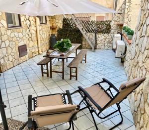 a patio with a table and chairs and an umbrella at AMATI HOLIDAYS in Palermo
