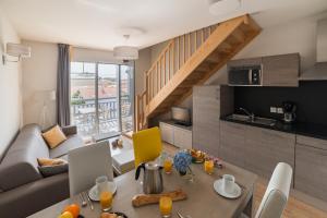 cocina y sala de estar con mesa y sofá en Lagrange Vacances Les Balcons de l'Océan, en Biscarrosse