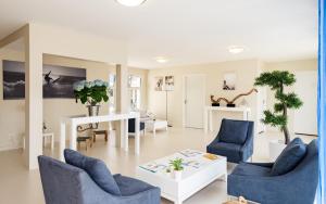 a living room with two blue chairs and a table at Lagrange Vacances Les Balcons de l'Océan in Biscarrosse