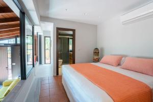 a bedroom with a large bed with orange sheets at Sea and Sun Metaxy Mas, brand-new, beachfront ! in Chania Town