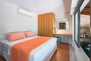 a bedroom with a large bed with orange and white sheets at Sea and Sun Metaxy Mas, brand-new, beachfront ! in Chania Town