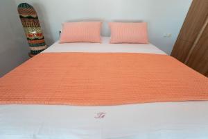 an orange and white bed with two pillows on it at Sea and Sun Metaxy Mas, brand-new, beachfront ! in Chania Town +23 photos