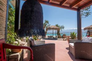a patio with chairs and a large black chandelier at Sea and Sun Metaxy Mas, brand-new, beachfront ! in Chania Town