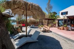 a chair under an umbrella and a table at Sea and Sun Metaxy Mas, brand-new, beachfront ! in Chania Town