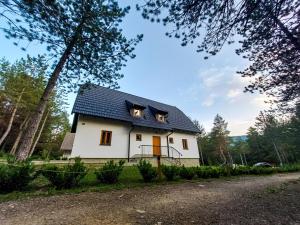 a small white house with a blue roof at Plitvice Story in Plitvička Jezera