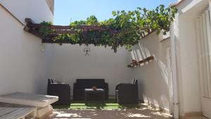 un patio con sillas, mesa y plantas en La Casa de Asensia, en Vélez Rubio