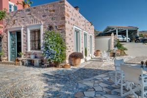 a brick building with a table and chairs on a patio at ALMA LIBRE SYROS in Ermoupoli