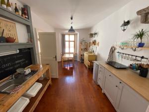 a kitchen with white cabinets and a wooden floor at Apartmán v Žltom dome in Banská Štiavnica