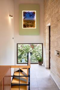 cocina con ventana grande y pared de piedra en Villa Olive Valley, en Loutrákion