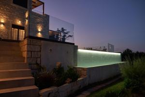 a swimming pool on the side of a house at night at Villa Olive Valley in Loutrákion