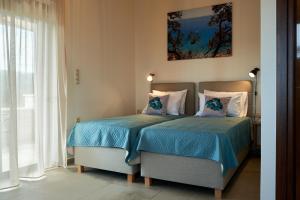 1 dormitorio con 2 camas y ventana en Villa Olive Valley, en Loutrákion