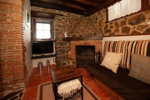 een woonkamer met een bank en een open haard bij Casa Rural El Corquieu de la Cava in San Feliz