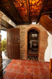 Habitación con pared de ladrillo y chimenea de piedra. en Casa Rural El Corquieu de la Cava en San Feliz