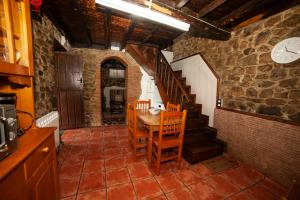 ein Esszimmer mit einem Tisch, Stühlen und einer Treppe in der Unterkunft Casa Rural El Corquieu de la Cava in San Feliz