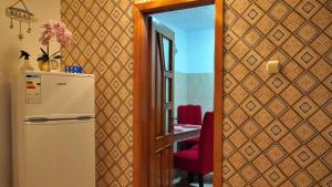 a kitchen with a refrigerator and a table with a red chair at Apartament Deny in Sulina