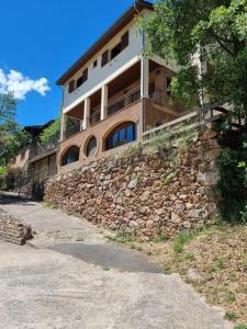 un gran edificio en la parte superior de una pared de piedra en Casa Teresina, en La Plana de Mont-Ros