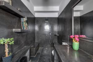 a bathroom with black walls and a sink with pink flowers at ALMA LIBRE SYROS in Ermoupoli +40 photos