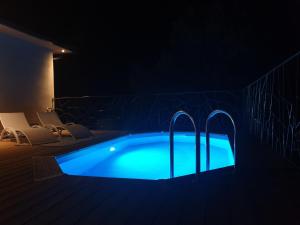 una piscina por la noche con iluminación azul en Domaine U Filanciu - Maison Chiara avec piscine - Centre Corse en Moltifao