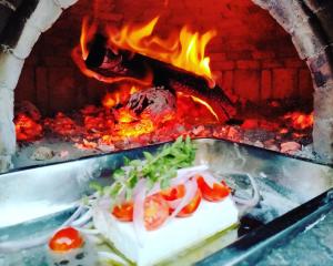 a pan filled with food on top of a fire at Villa Laura Apartment in Giardini Naxos