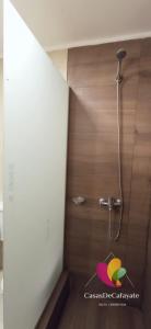 y baño con ducha y pared de madera. en Casas de Cafayate en Cafayate