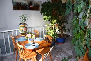 a wooden table and chairs on a balcony with plants at Przytulne duże mieszkanie w domku jednorodzinnym in Koszalin