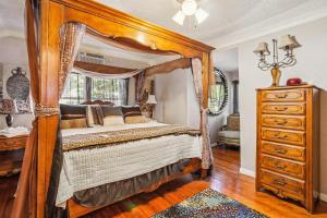 a bedroom with a canopy bed and a dresser at The Old Downtown Historic Grand Prairie House home in Grand Prairie