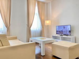 a living room with a couch and a table and a tv at Steiner Residences Vienna Augarten in Vienna