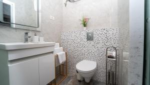 a white bathroom with a toilet and a sink at Casi in Saturn +23 photos