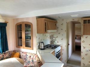 a kitchen with a couch and a stove top oven at Siódme Niebo na Cuplu in Serock