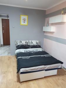 um quarto com uma cama com um edredão preto em Apartament Mario em Kolno