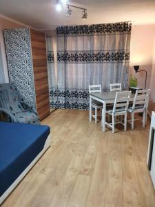 een woonkamer met een eettafel en stoelen bij Apartament Mario in Kolno