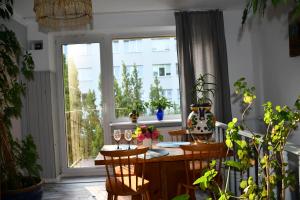a dining room with a table and chairs and a window at Przytulne duże mieszkanie w domku jednorodzinnym in Koszalin