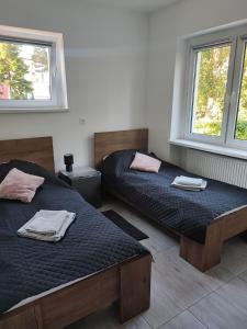 a bedroom with two beds and two windows at Bella Rossi in Jastrzębia Góra