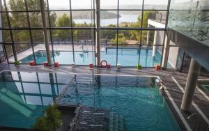 a large swimming pool in a building with windows at Casa Cueva Salamandra con chimenea y piscina privada in Pozo Alcón