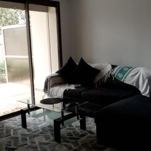 a living room with a couch and a glass table at Studio Tamourit Taghazout Bay à 300 m de la plage in Taghazout